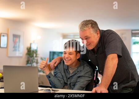 Father using laptop with son Stock Photo