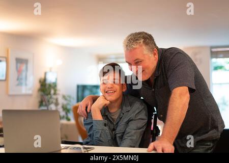 Father using laptop with son Stock Photo