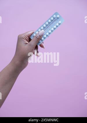 Close-up of womans hand holding birth control pills Stock Photo