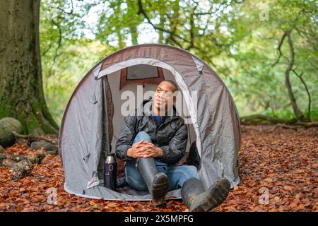 Man camping in forest at autumn Stock Photo