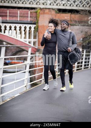Smiling athletic couple walking outdoors Stock Photo