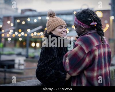 Smiling couple in city at dusk Stock Photo