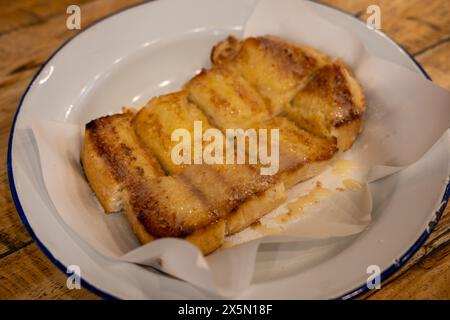 Sliced bread with butter, milk and sugar served on plate Stock Photo