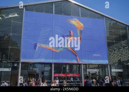 Paris, France. 10 May, 2024. A giant poster by Italian artist Lorenzo Mattotti of  an olympic torch bearer is displayed at the entrance to  Paris Gare du Nord .  Paris will host the 2024 Summer Olympics, of the XXXIII Olympiad scheduled to take place from 26 July to 11 August . Credit: amer ghazzal/Alamy Live New Stock Photo