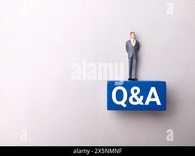 Top view miniature people with text Q AND A on white background Stock Photo