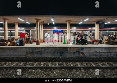 Passengers wait on the platform at Luxor Railway Station, Egypt, at night Stock Photo