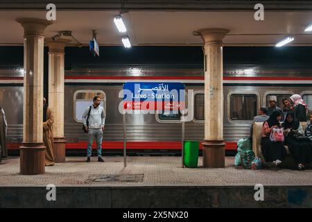 Passengers wait on the platform at Luxor Railway Station, Egypt, at night Stock Photo