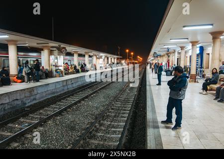 Passengers wait on the platform at Luxor Railway Station, Egypt, at night Stock Photo