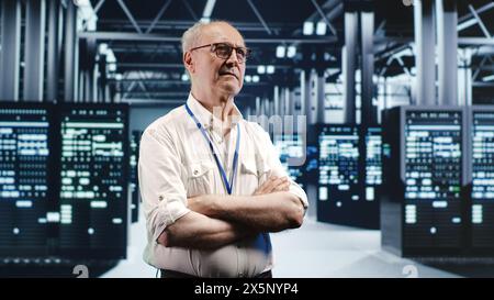 Portrait of elderly engineer looking around modern server room in data center, preparing to start comission on malfunctioning high tech facility hardware rigs in order to ensure errorless operations Stock Photo