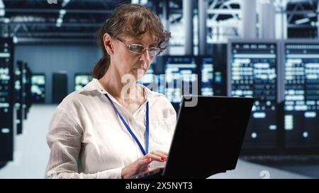 Knowledgeable supervisor looking around advanced data center, preparing to start comission on damaged high tech blade servers in order to ensure optimal operations Stock Photo