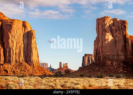 Mountainside lit up by a rising sun casts an orange color against the landscape in Monument Valley, Arizona, a southwest destination for adventure see Stock Photo