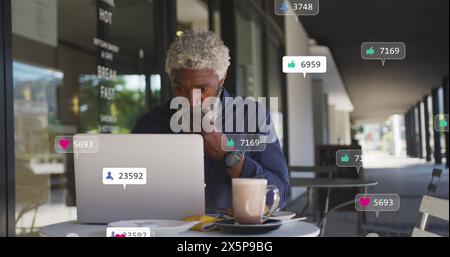 Middle-aged African American chef/restaurant owner using laptop at cafe Stock Photo