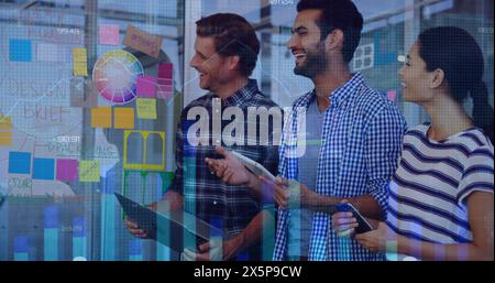 Diverse group of friends standing, looking at colorful notes on glass Stock Photo