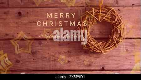 A golden wreath hanging on wooden wall with festive greetings Stock Photo