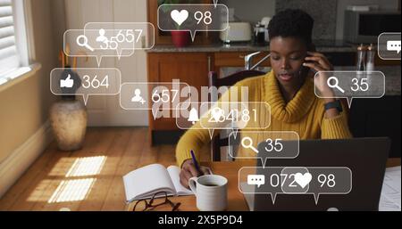 African American woman wearing yellow sweater is writing notes Stock Photo