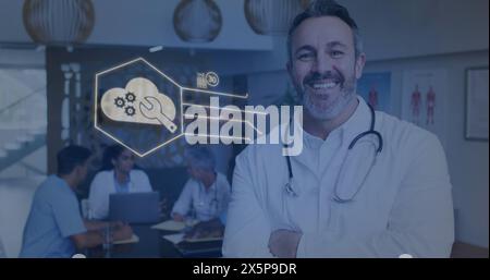 Middle-aged Caucasian male doctor smiling, diverse team working behind Stock Photo