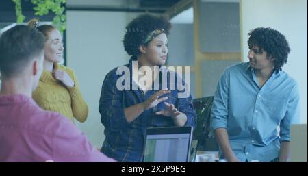 Diverse team discussing work, biracial woman leading. She has curly hair, wearing casual clothes, holding spreadsheet Stock Photo
