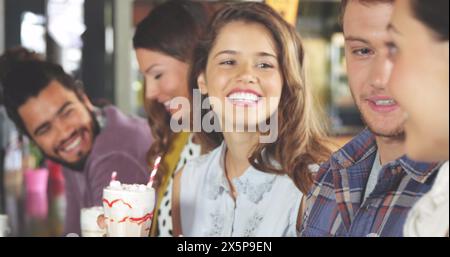 Group of diverse friends enjoying time together, holding drinks Stock Photo