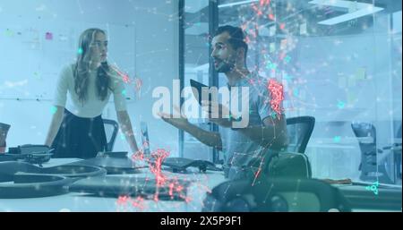 Diverse team discussing over tablet in office Stock Photo