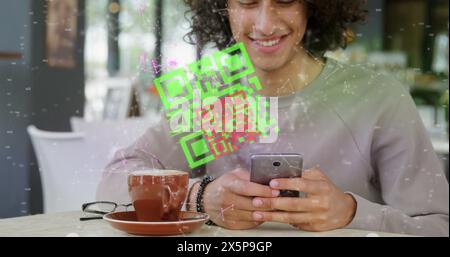 A biracial young man with curly hair is scanning QR code with his smartphone Stock Photo