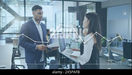 Image of graph with changing numbers over diverse coworkers discussing reports in office Stock Photo