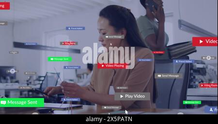 Image of multiple notification bars over asian woman using graphics tablet in office Stock Photo