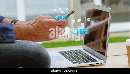 Middle-aged Caucasian male using smartphone and laptop Stock Photo