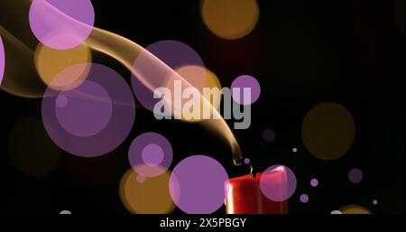 Image of violet and yellow dots over fading out candle on black background Stock Photo