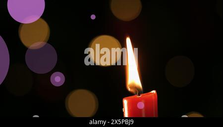 Candle flame burning brightly against dark background Stock Photo