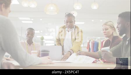 Diverse group of fashion designers discussing over sketches Stock Photo