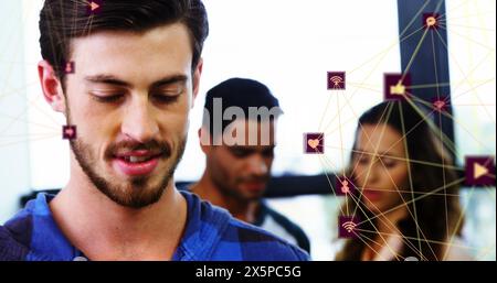 Image of two globes of digital icons over caucasian man smiling while using smartphone at office Stock Photo