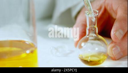 Image of german over caucasian male scientist pouring liquid into laboratory beaker Stock Photo