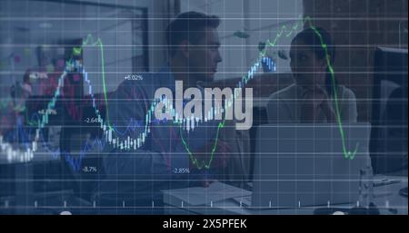 Image of financial data processing against diverse man and woman discussing at office Stock Photo