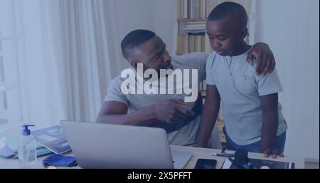 African American father pointing at laptop screen, son watching closely Stock Photo