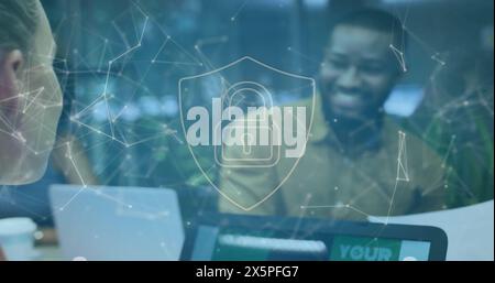 Image of padlock in shield and connected dots over diverse coworkers discussing on desk Stock Photo