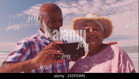 Image of joy over happy diverse senior couple taking selfie on beach Stock Photo