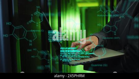 Image of medical data processing over mid section of male engineer using laptop at server room Stock Photo