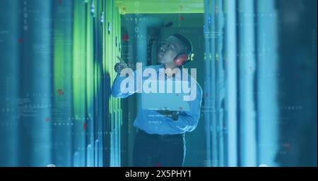 Image of computer language, binary codes, african american male engineer checking server racks Stock Photo