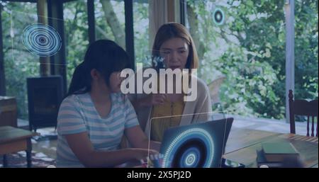 Image of data processing against asian mother and daughter using laptop at home Stock Photo
