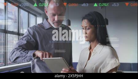 Statistical data processing against diverse male and female office colleagues discussing at office Stock Photo