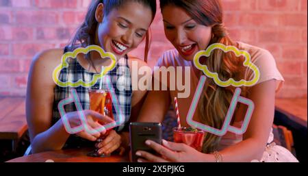 Image of beer icons over happy caucasian female friends using smartphone Stock Photo