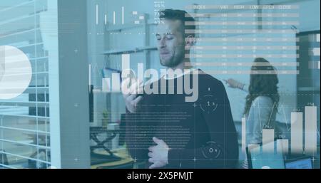Image of infographic interface, smiling caucasian man talking on speaker of cellphone in office Stock Photo