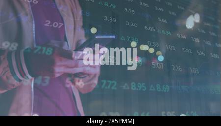 Image of graphs and trading board over midsection of caucasian man typing on cellphone Stock Photo
