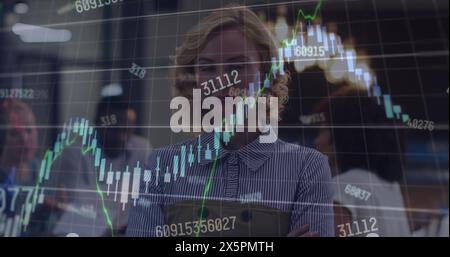 Image of financial data processing against portrait of caucasian woman smiling at office Stock Photo