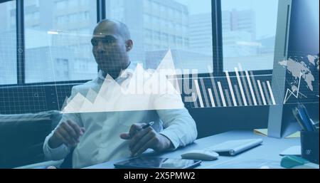 Image of statistical data processing against thoughtful biracial man at office Stock Photo