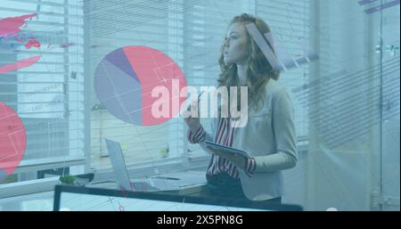 Image of statistical data processing against thoughtful caucasian woman taking notes at office Stock Photo