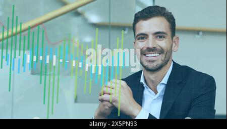 Image of multiple graphs over smiling caucasian man sitting on sofa at office Stock Photo