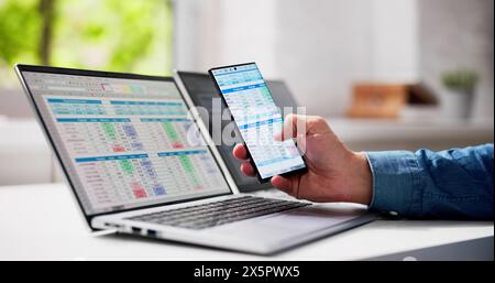 Man Using Spreadsheet Data On Laptop Computer Stock Photo