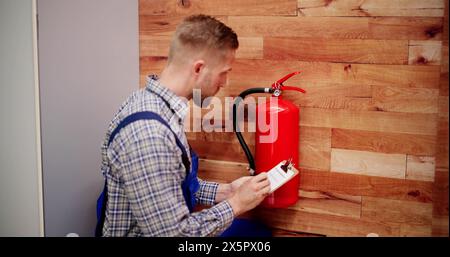 Close-up Of Male Professional Checking A Fire Extinguisher Stock Photo