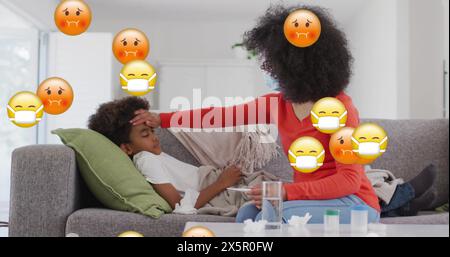 Biracial mother checking on her son lying on couch, both looking tired Stock Photo